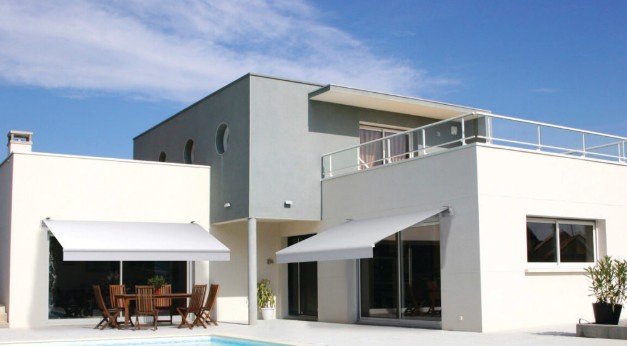 Retractable motorized awning extended over patio seating area on a sunny day